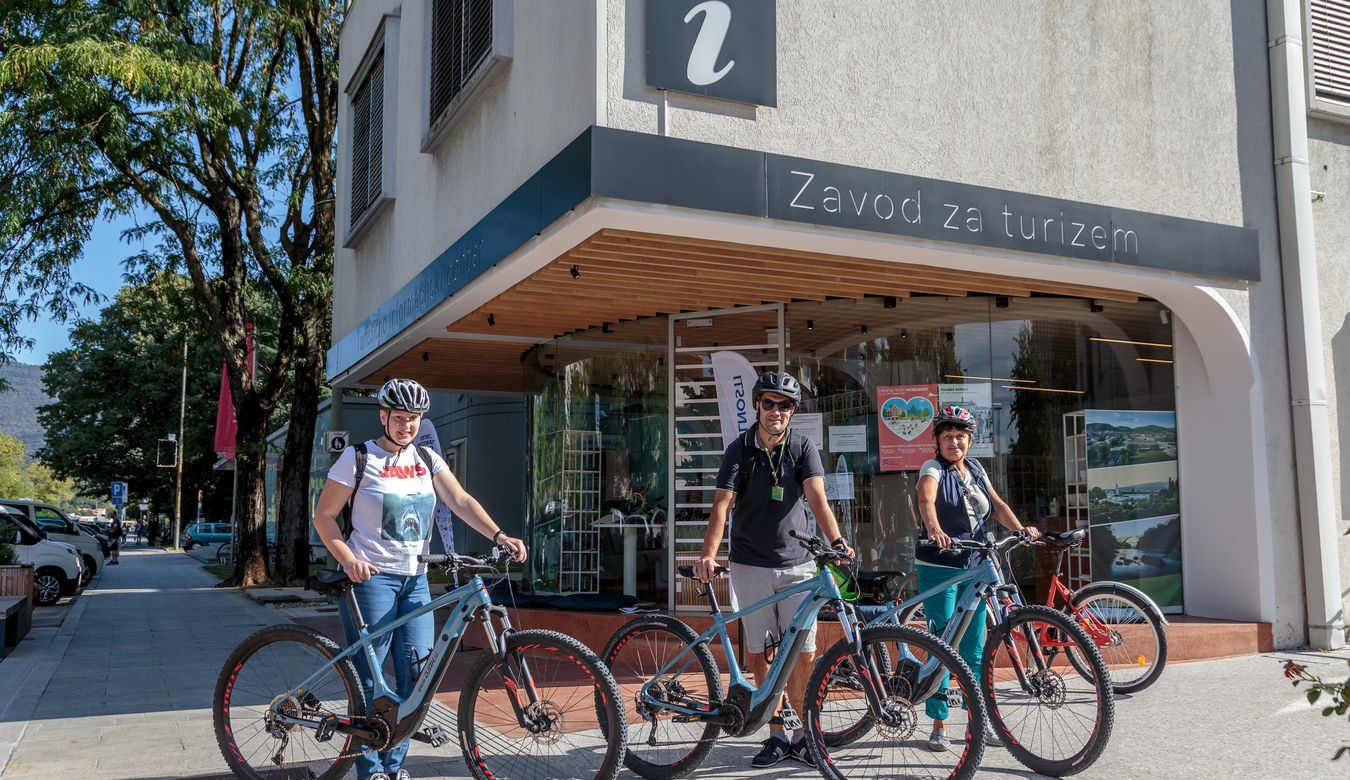 Kolesarji s kolesi stojijo pred sedežem Javnega zavoda za turizem Nove Gorice in Vipavske doline