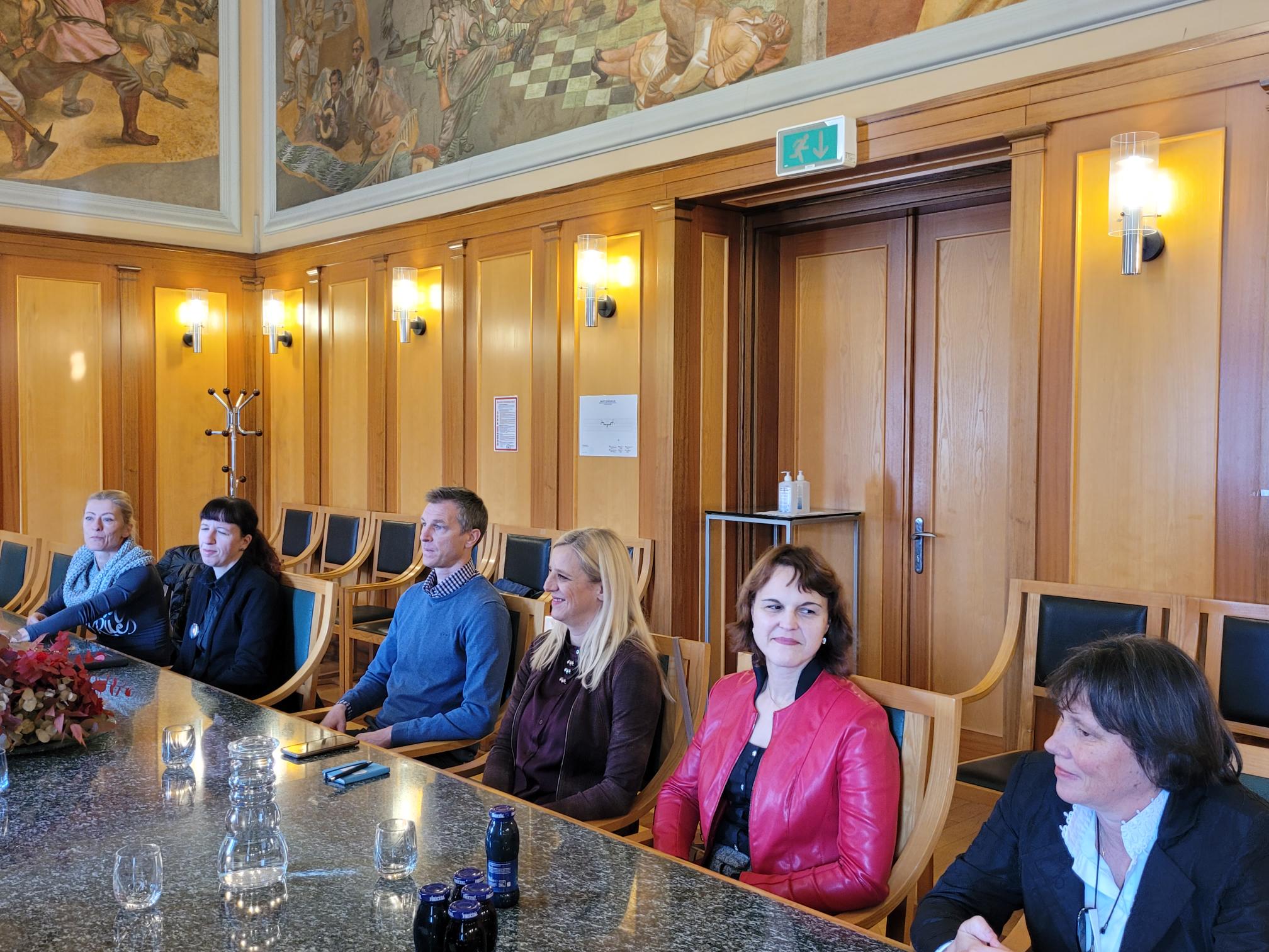 Srečanje župana z direktorji javnih zavodov, udeleženci sedijo ob mizi v Zeleni dvorani občinske stavbe