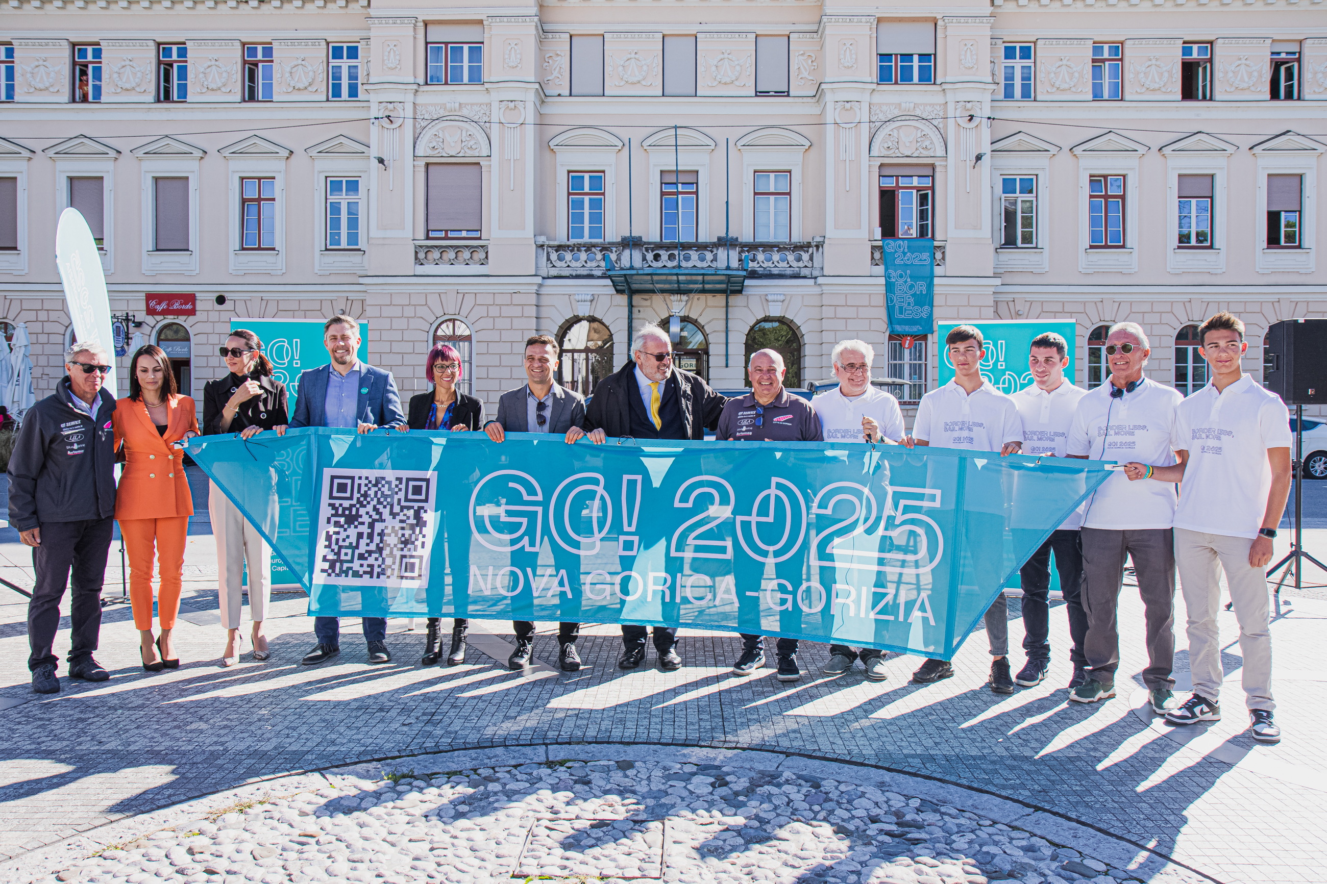 Zastava Evropske prestolnice kulture 2025 in udeleženci novinarske konference, ki zastavo držijo v rokah