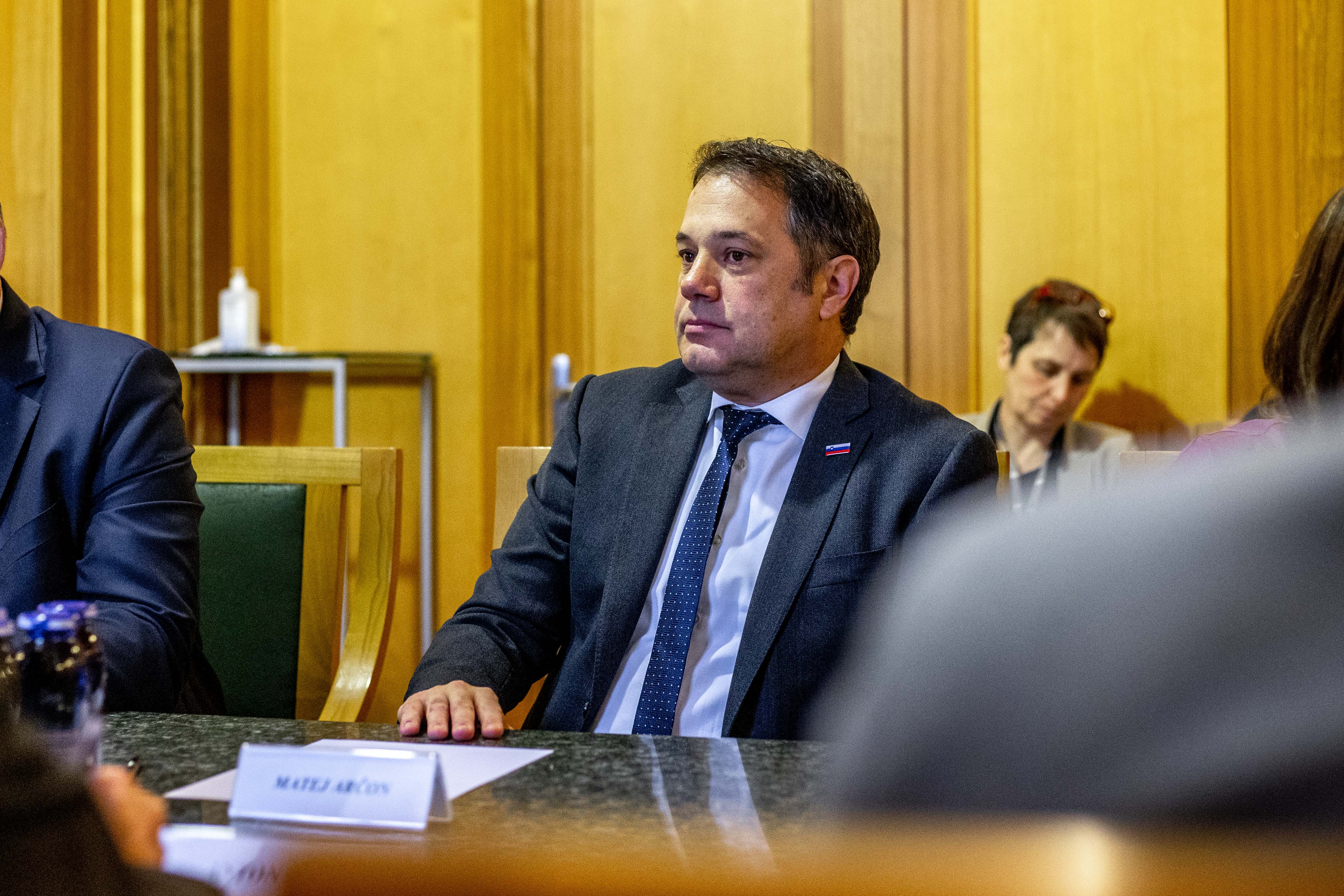 Minister Matej Arčon sedi za mizo na sestanku v zeleni dvorani mestne občine
