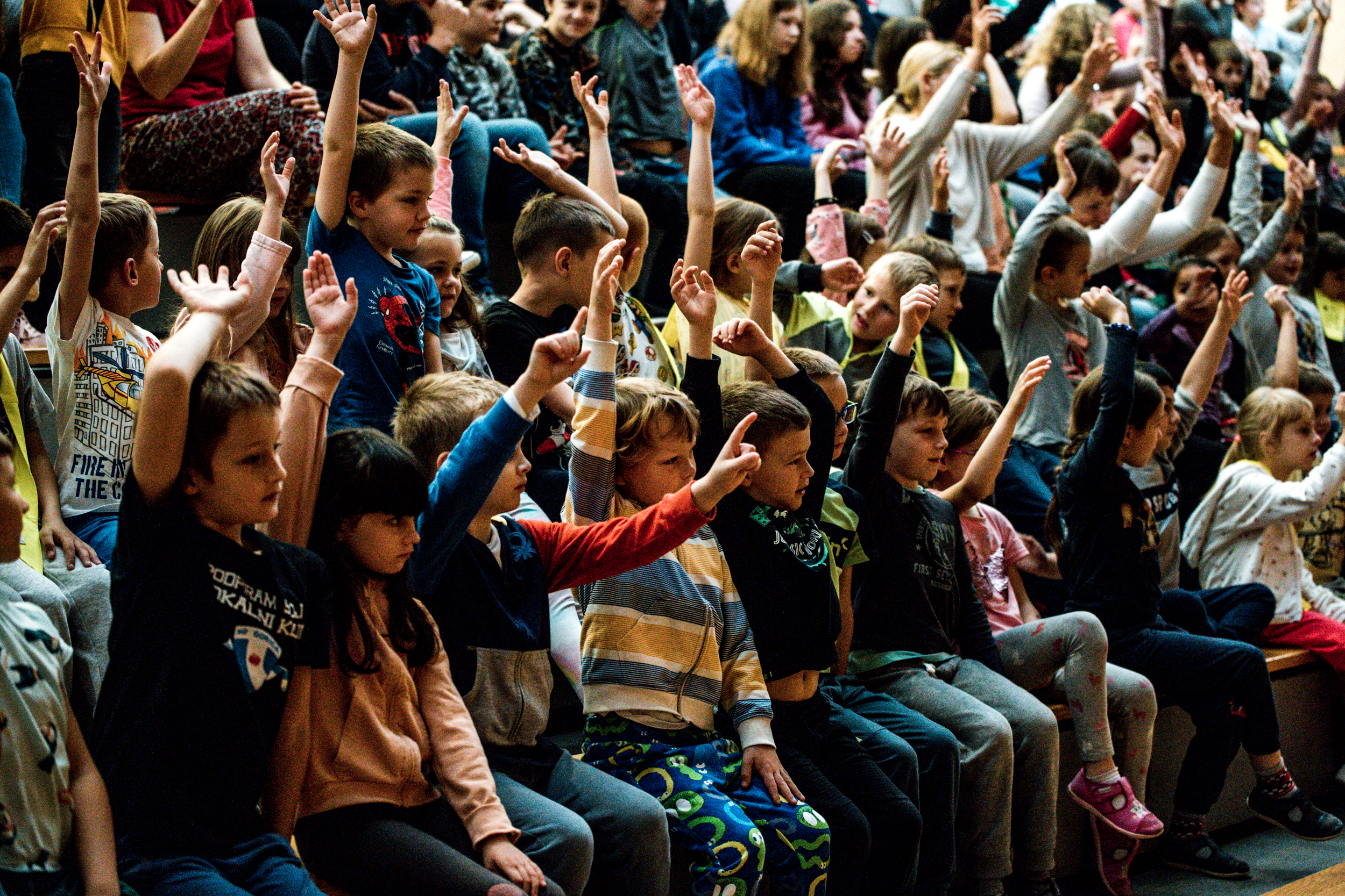 Otroci v občinstvu dvigujejo roko