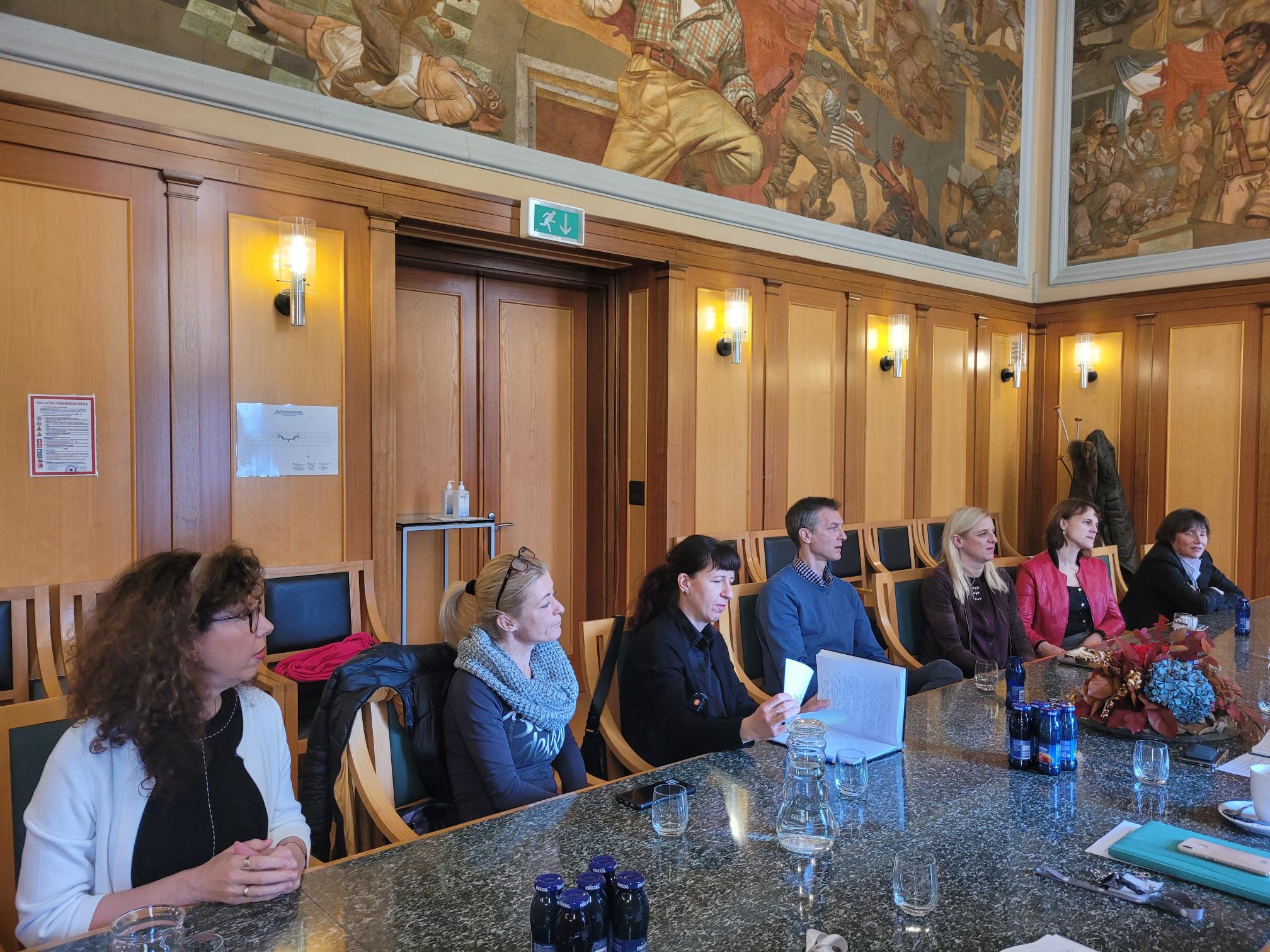 Srečanje župana z direktorji javnih zavodov, udeleženci sedijo ob mizi v Zeleni dvorani občinske stavbe